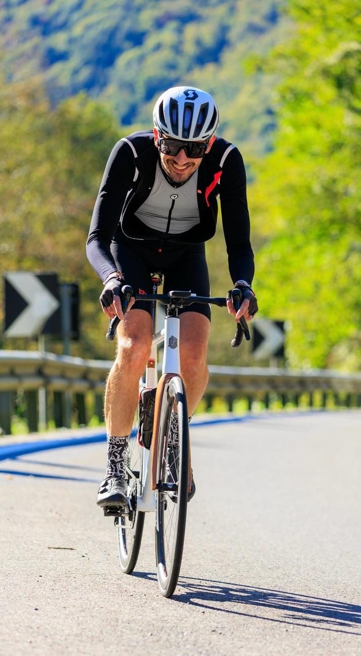 Andrea de Milan souriant en montée sur son vélo Forgione
